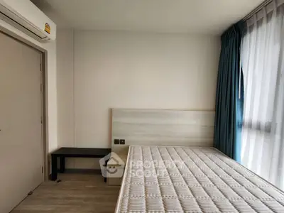 Spacious bedroom with natural light and modern furnishings in a stylish apartment.