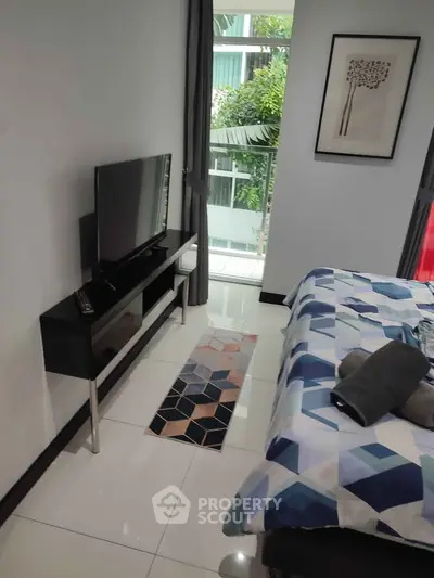 Modern bedroom with stylish decor and large window offering natural light and garden view.