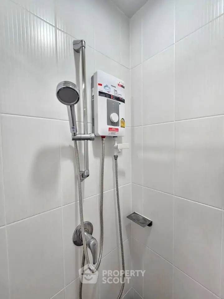 Modern bathroom with sleek shower and water heater in a tiled corner.