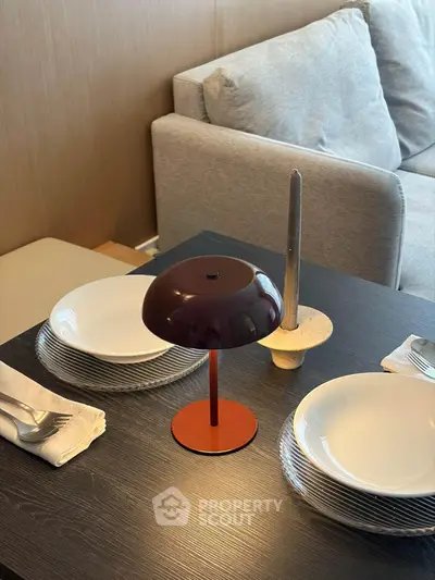Modern dining setup with stylish lamp and cozy sofa in elegant living room.