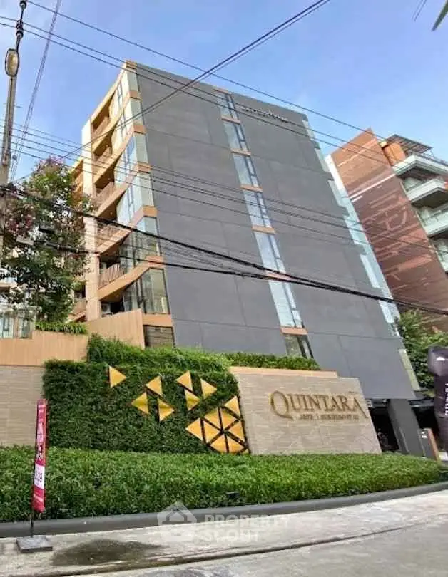Modern condominium building exterior with lush greenery and stylish facade in urban setting.