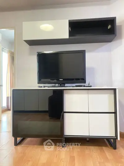 Modern living room with sleek TV stand and mounted cabinet, showcasing minimalist design and functionality.