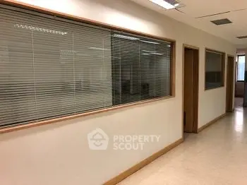 Spacious office corridor with large windows and modern lighting