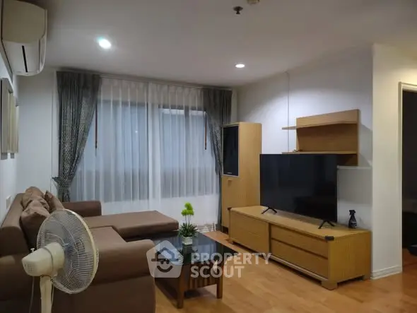 Cozy living room with modern furniture and large TV, perfect for relaxation.