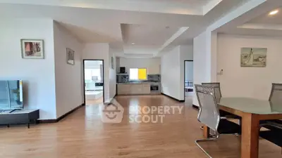 Spacious open-plan living and dining area with modern kitchen in a stylish apartment.