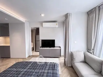 Modern living room with sleek design, featuring a cozy sofa, TV, and air conditioning.