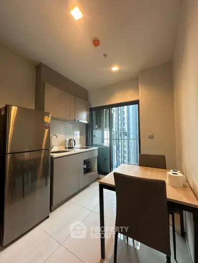 Modern kitchen with sleek appliances and dining area in a stylish apartment.