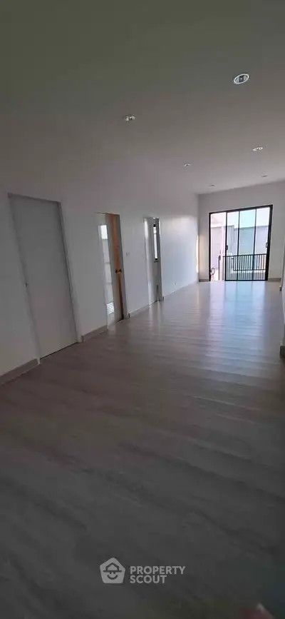 Spacious modern living room with large windows and balcony access