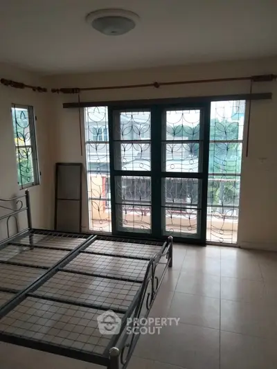 Spacious bedroom with large windows and balcony access, ideal for natural light lovers.