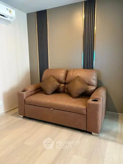 Modern living room with stylish brown leather sofa and elegant wall design.