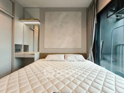 Modern bedroom with stylish decor and large window offering natural light