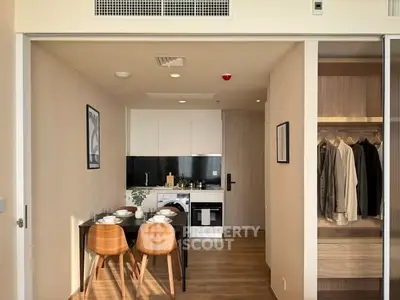 Modern compact kitchen with dining area and built-in wardrobe in stylish apartment