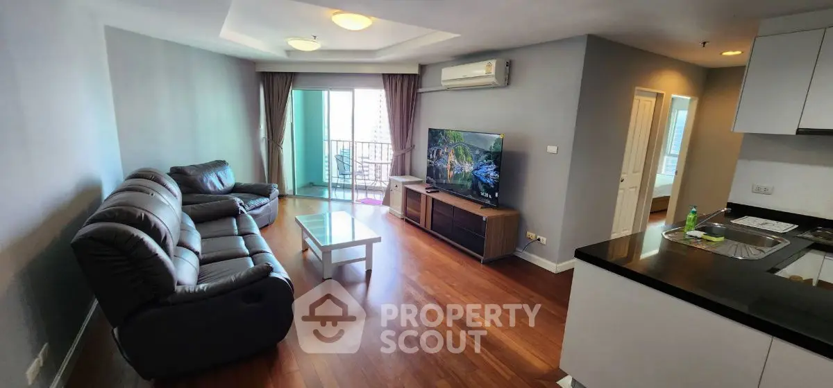 Spacious living room with modern furniture and balcony access in a stylish apartment.