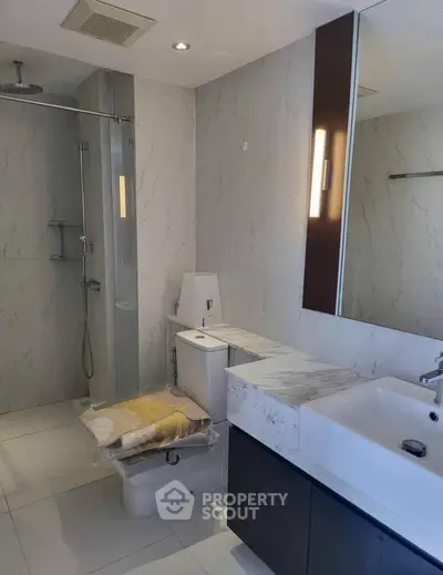 Modern bathroom with sleek fixtures and marble countertop in a contemporary apartment.