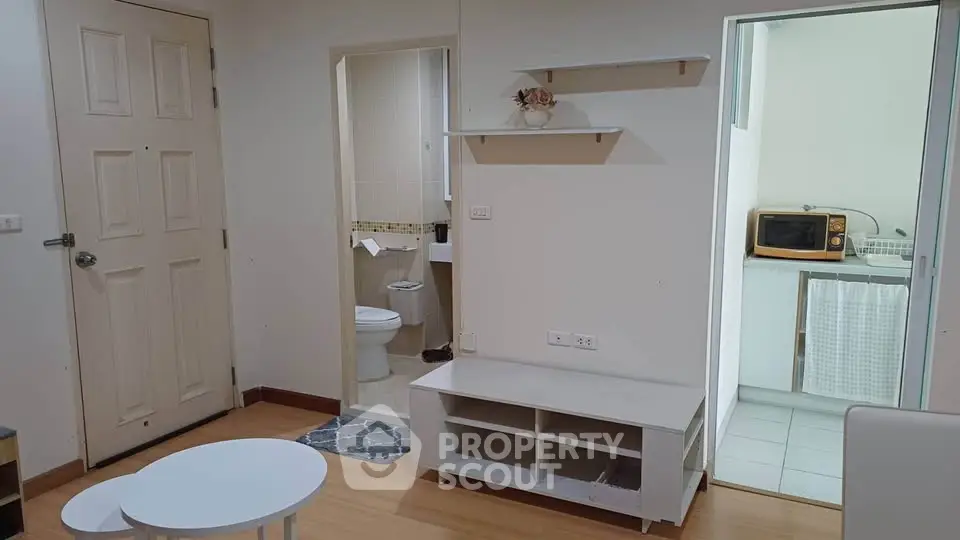 Cozy apartment interior with open layout, featuring a compact kitchen and bathroom, ideal for urban living.