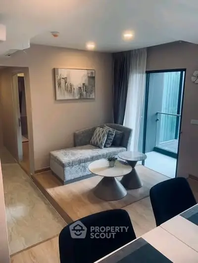 Modern living room with stylish furniture and balcony access in a contemporary apartment.