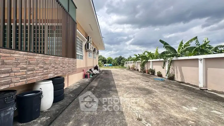 Spacious outdoor area with lush greenery and modern building exterior, perfect for relaxation and leisure.
