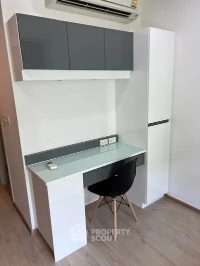 Modern study area with sleek desk and chair under air conditioning unit