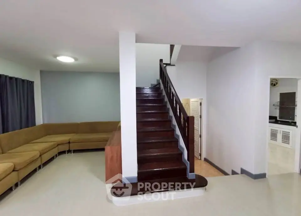 Spacious living room with modern staircase and cozy sectional sofa