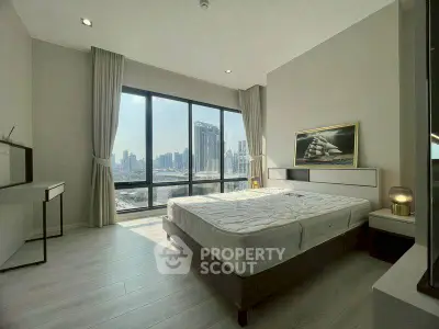Spacious bedroom with stunning city view and modern decor in luxury apartment.