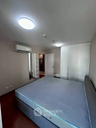 Spacious bedroom with modern design, featuring a large bed and built-in wardrobe, perfect for comfortable living.