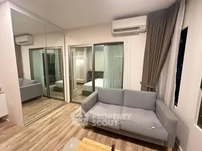 Modern living room with mirrored closet and cozy sofa in stylish apartment