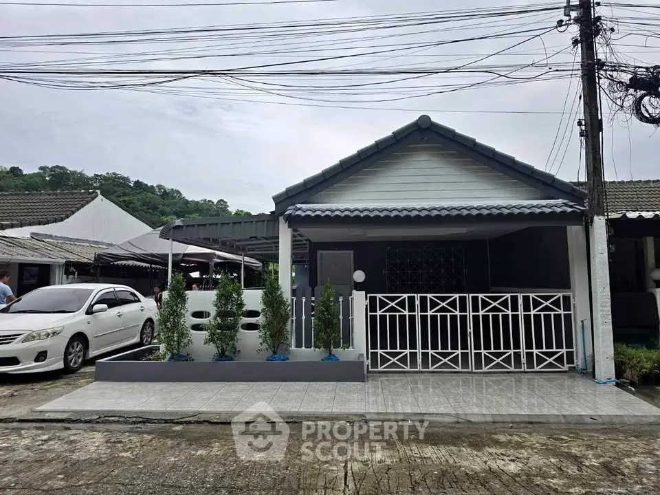 Charming single-story house with modern fence and driveway in a serene neighborhood.