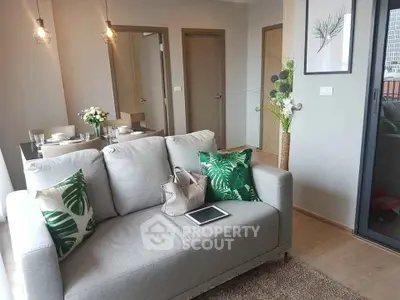 Modern living room with stylish decor and natural light, featuring a cozy sofa and dining area.