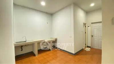 Spacious kitchen area with tiled floor and modern sink, ideal for culinary enthusiasts.