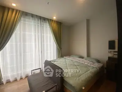 Cozy bedroom with large window and elegant curtains, featuring a comfortable bed and modern decor.