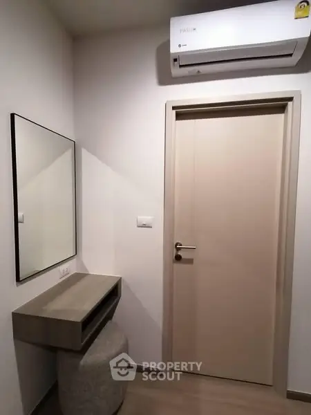 Modern minimalist hallway with air conditioning and sleek console table.