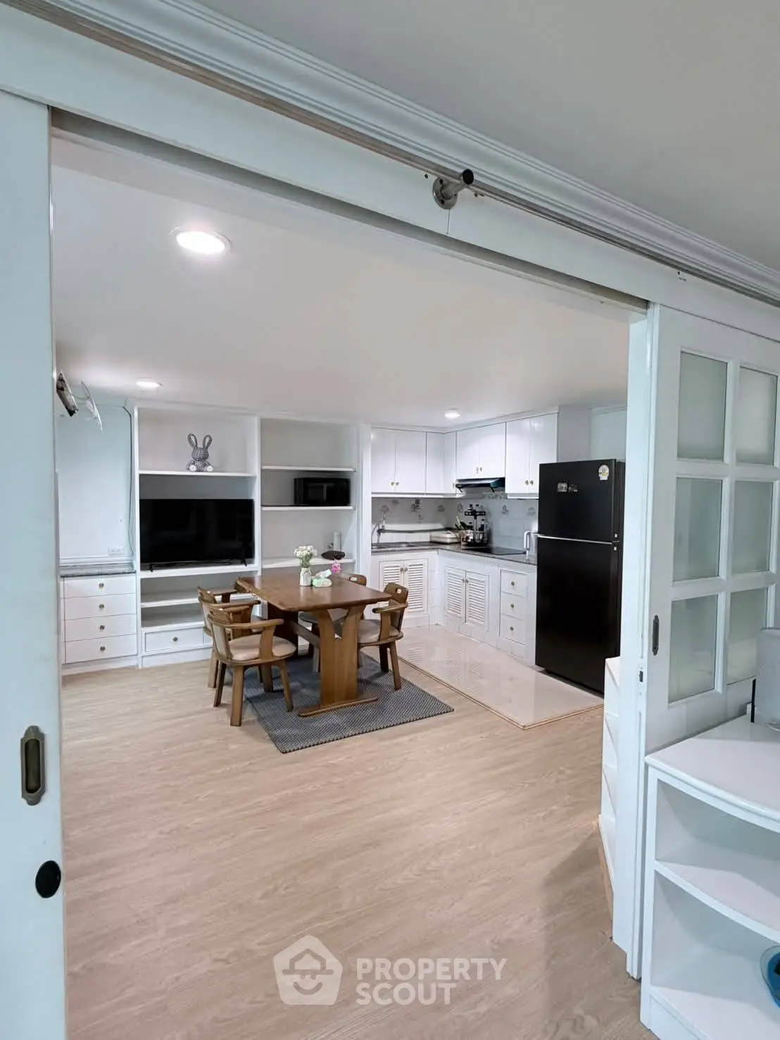 Spacious kitchen with dining area, modern appliances, and elegant wooden flooring
