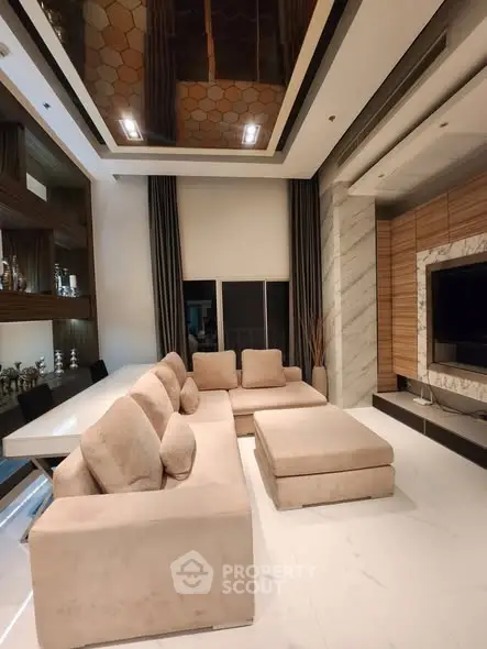 Luxurious modern living room with plush beige sectional sofa and sleek entertainment center.
