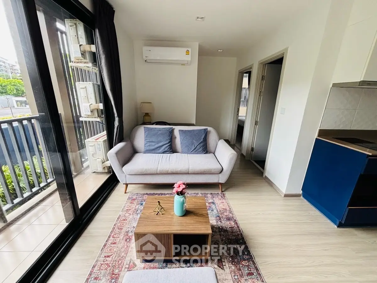Modern living room with cozy sofa, air conditioning, and balcony view in stylish apartment.