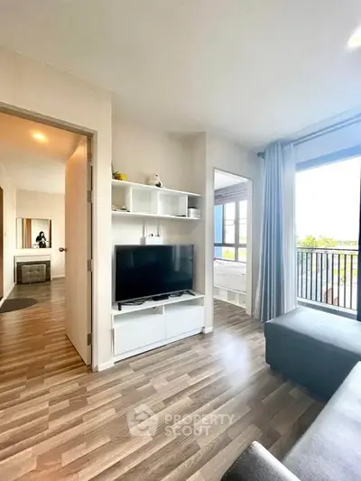 Modern living room with sleek TV unit and balcony view