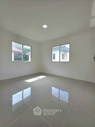 Bright empty room with large windows and glossy tiled floor, perfect for customization.
