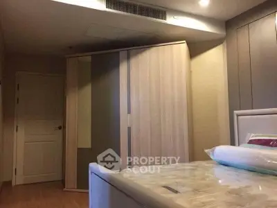 Spacious bedroom with modern wardrobe and comfortable bed in a stylish apartment.