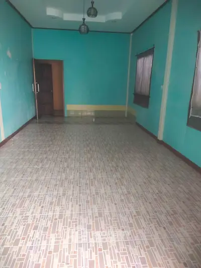 Spacious empty room with tiled floor and teal walls, ready for customization.