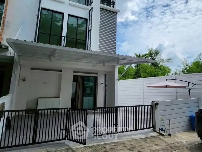 Modern townhouse exterior with gated entrance and covered patio area.