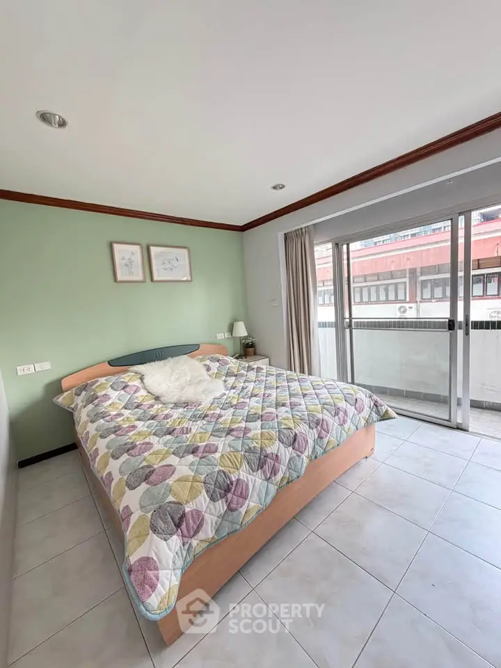 Spacious bedroom with large bed and balcony access in modern apartment