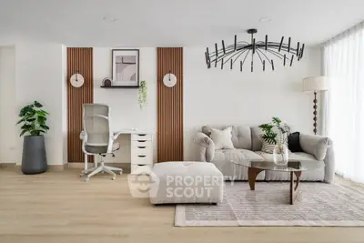 Modern living room with stylish decor, featuring a cozy sofa, elegant chandelier, and natural light.
