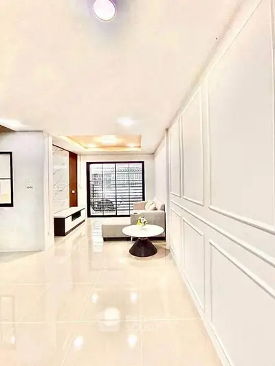 Elegant modern living room with sleek design and natural light, featuring stylish furniture and glossy flooring.