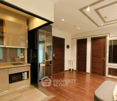 Modern living room with sleek kitchen and wooden flooring