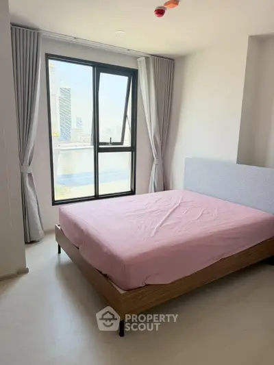 Modern bedroom with large window offering stunning city view, featuring minimalist decor and natural light.
