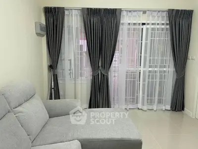 Spacious living room with elegant gray curtains and comfortable sofa, perfect for relaxation.