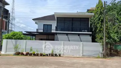 Modern two-story house with large windows and a sleek exterior design.