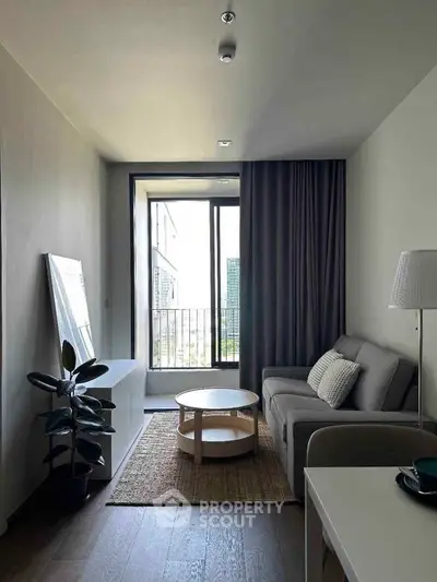 Modern living room with cozy sofa, stylish decor, and balcony view in urban apartment.