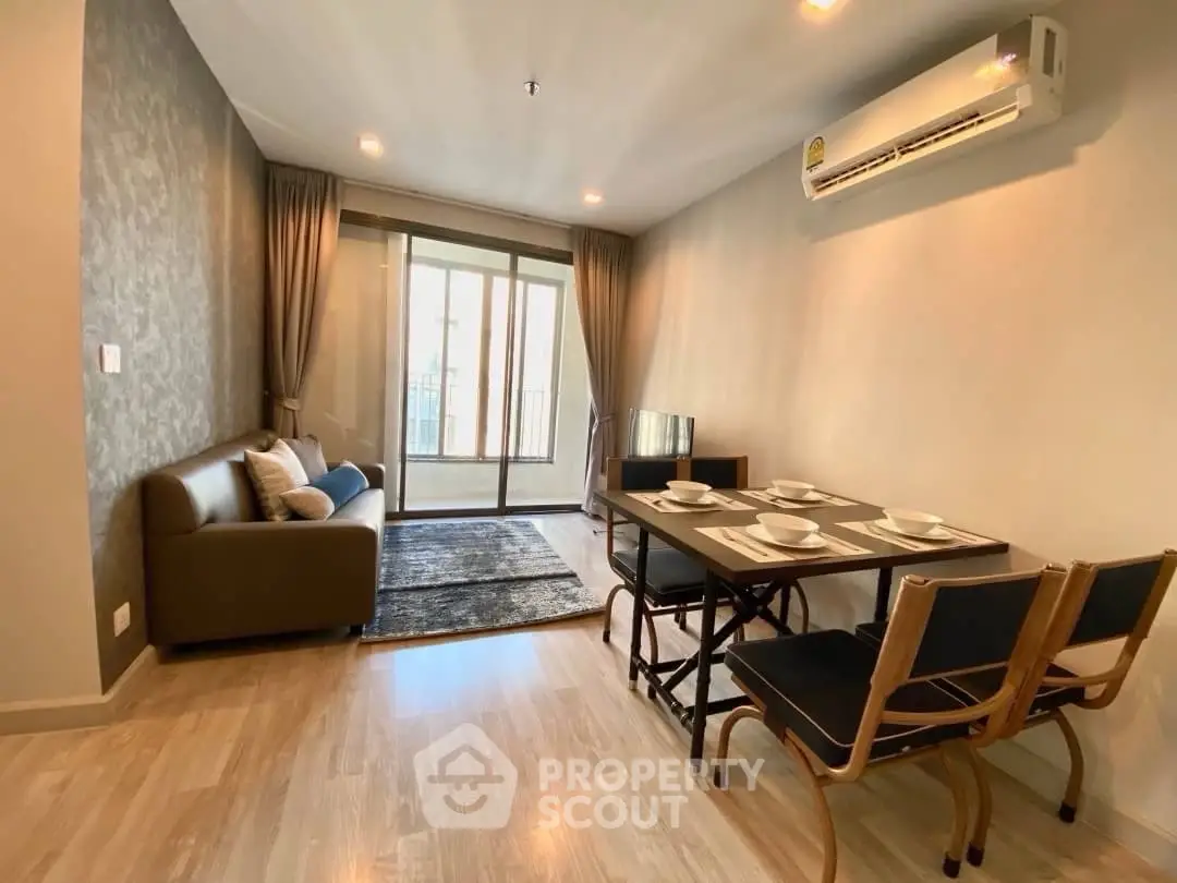 Modern living room with dining area and balcony access in a stylish apartment.