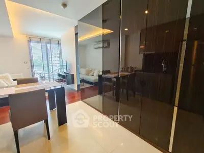 Modern living room with sleek furniture and large windows offering natural light.
