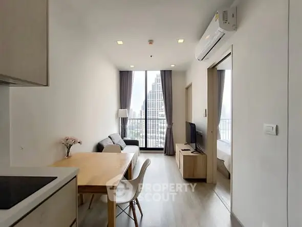 Modern living room with city view, featuring sleek furniture and natural light.